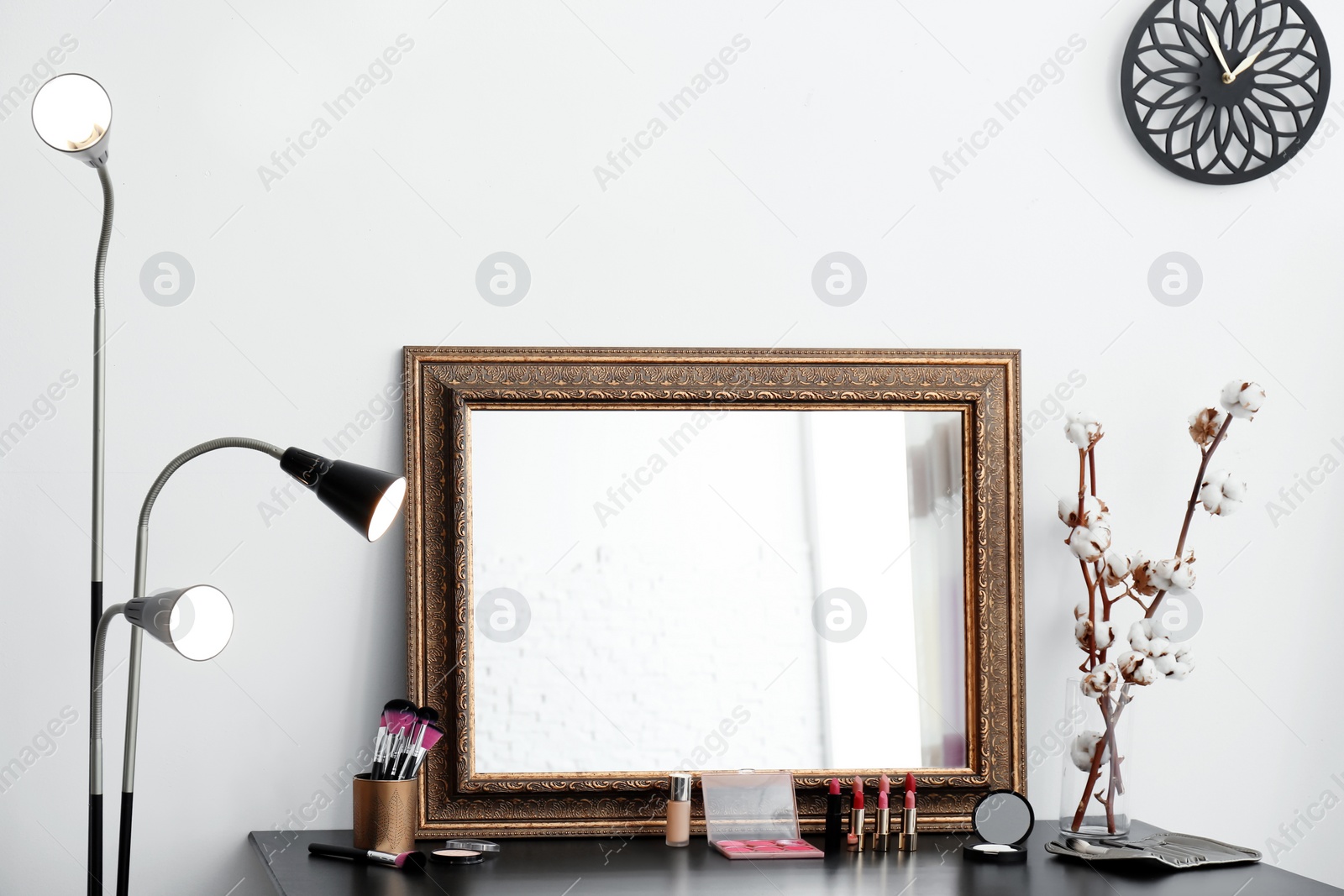 Photo of Decorative cosmetics and tools on dressing table near mirror in makeup room