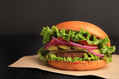 Photo of One tasty burger on wooden table, closeup. Space for text