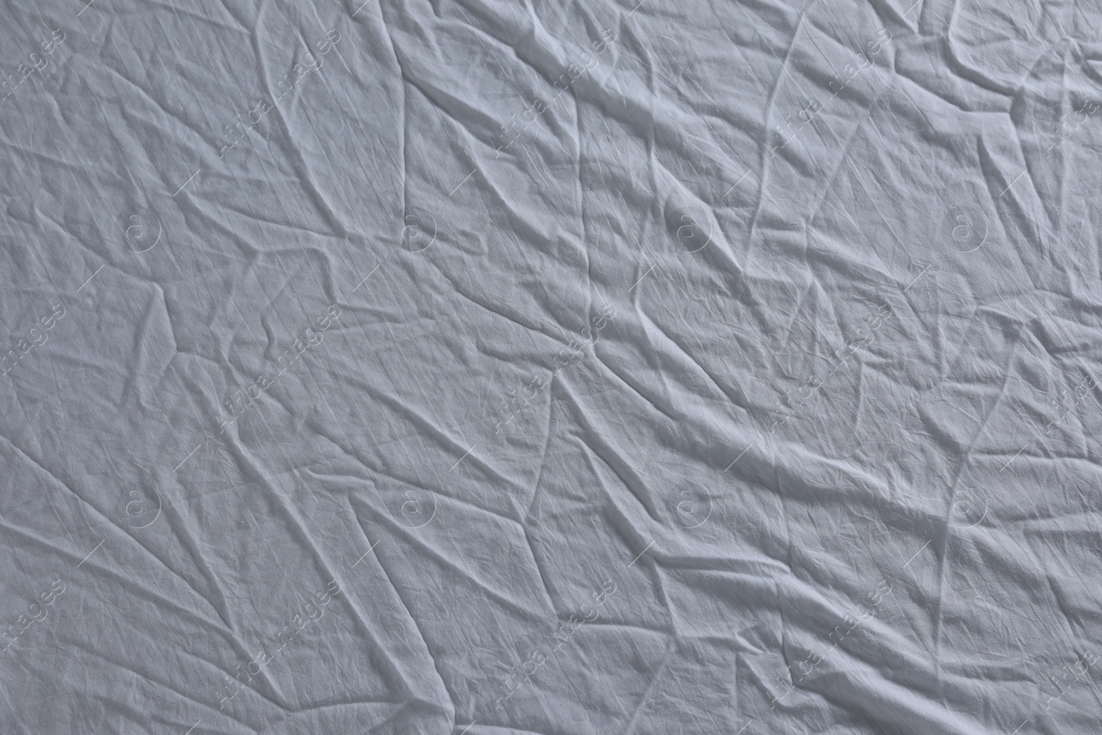 Photo of Crumpled white fabric as background, top view