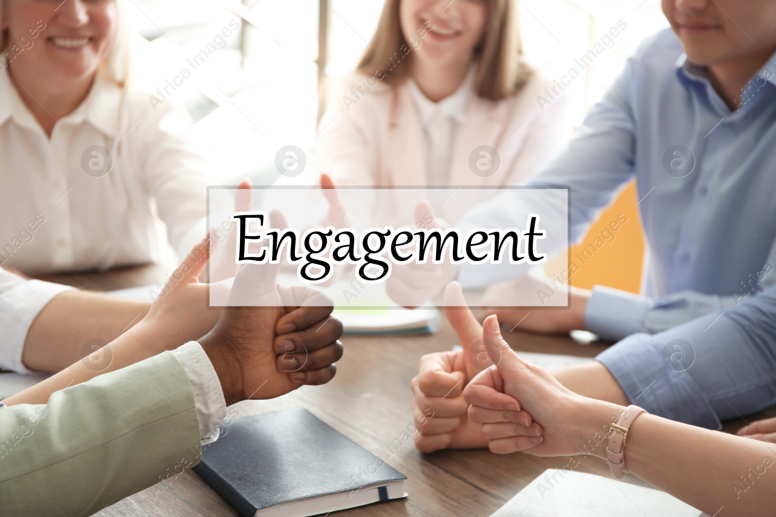 Image of Engagement concept. People showing thumbs up together at table, closeup