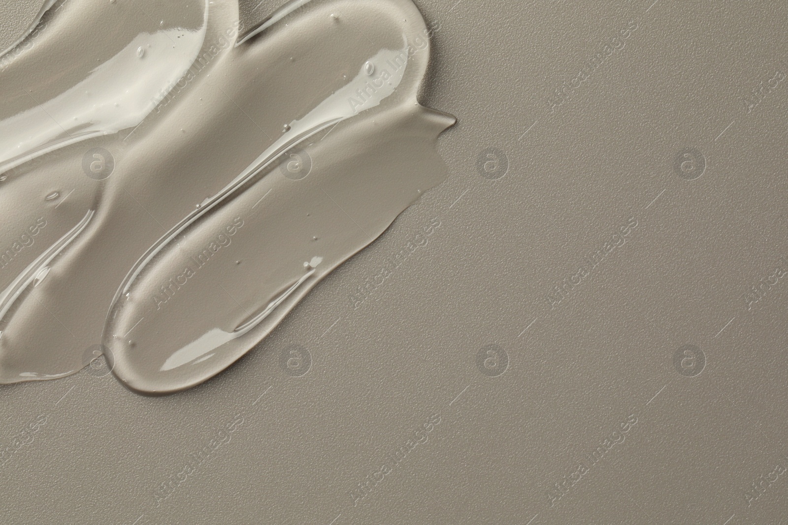 Photo of Sample of clear cosmetic gel on grey background, top view. Space for text