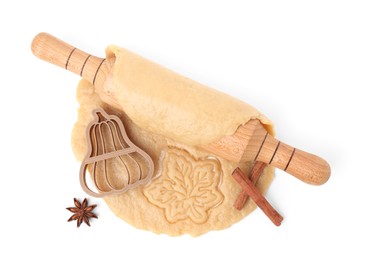 Cookie cutter, dough, spices and rolling pin on white background, top view