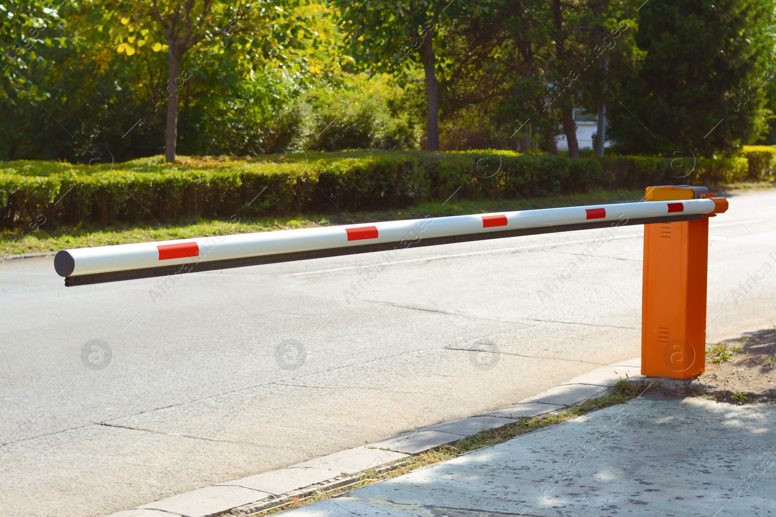 Photo of Closed boom barrier near road on sunny day