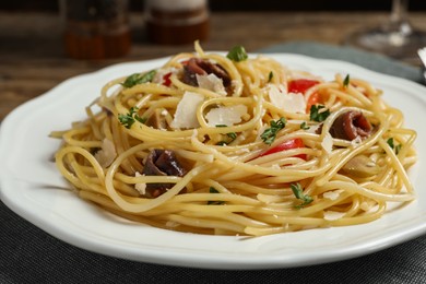 Delicious pasta with anchovies, tomatoes and parmesan cheese on table, closeup