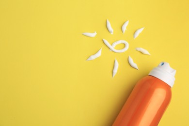 Photo of Drawing of sun and bottle with sunscreen on yellow background, top view and space for text. Skin protection