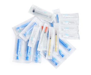 Photo of Different packed disposable syringes with needles on white background, top view