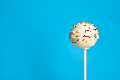 Photo of Bright delicious cake pop on color background. Space for text