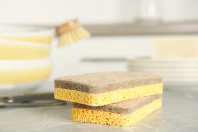 Photo of Cleaning sponges for dish washing on grey marble table, closeup