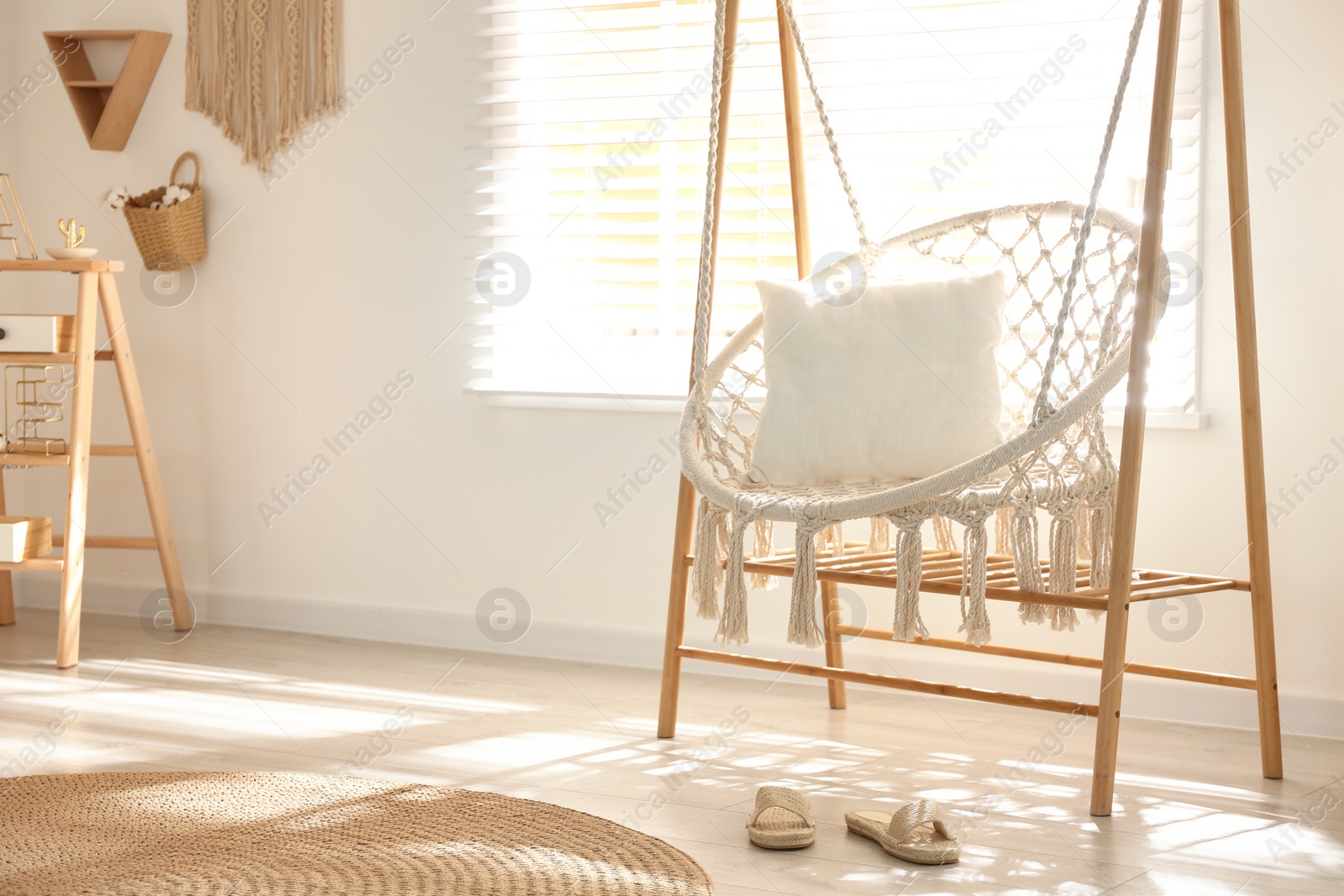 Photo of Comfortable hammock chair in stylish room. Home interior