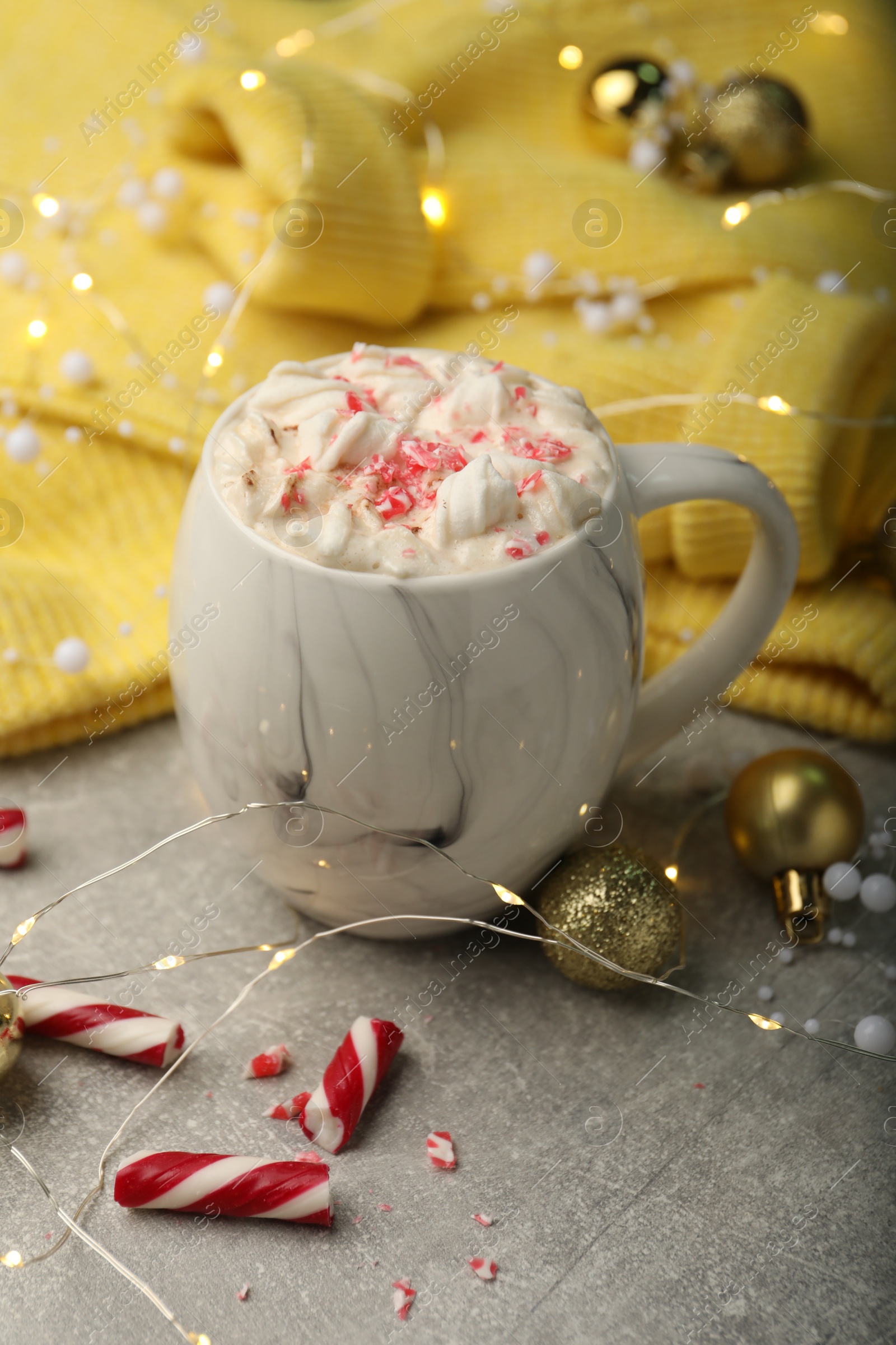 Photo of Composition with delicious marshmallow drink, festive decor and yellow sweater on light grey table