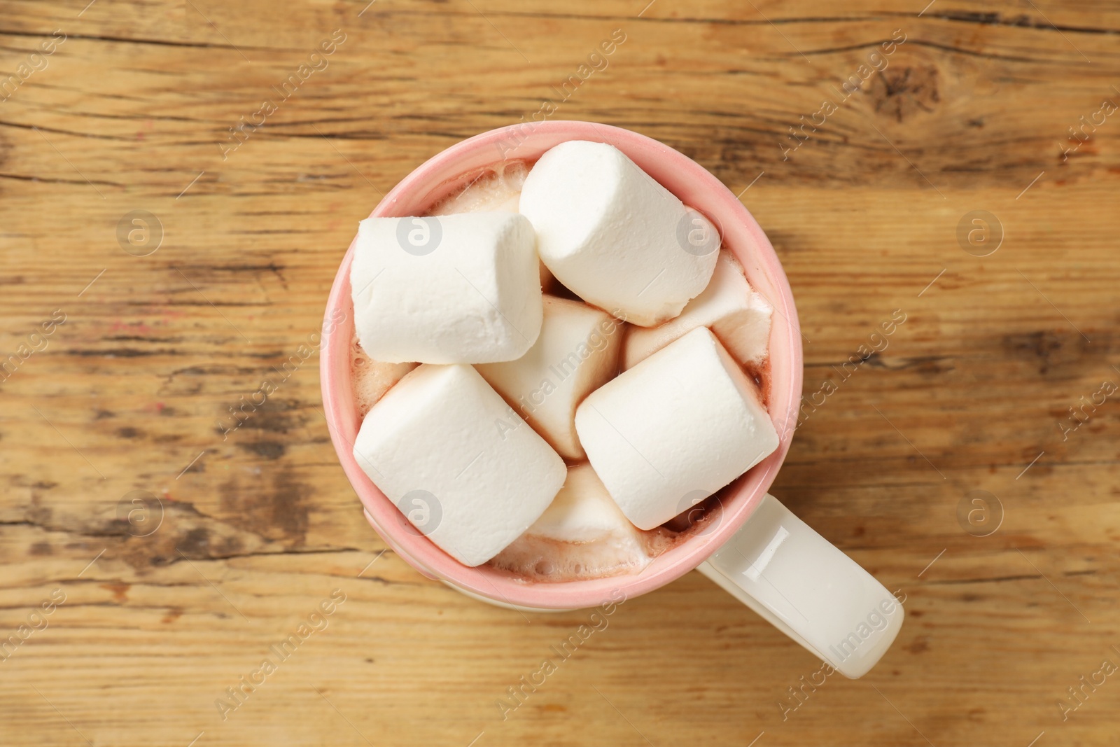 Photo of Tasty hot chocolate with marshmallows on wooden table, top view