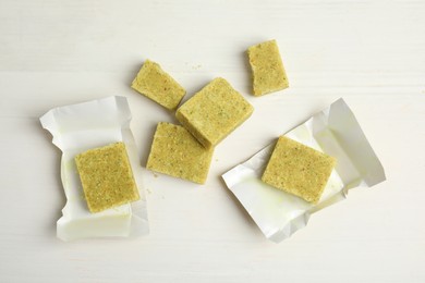Bouillon cubes on white wooden table, flat lay