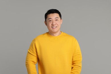 Portrait of happy man on grey background