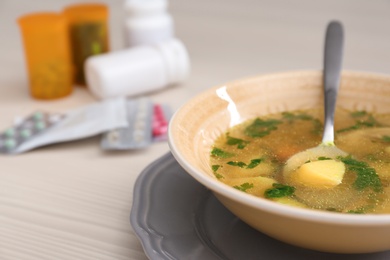 Bowl with delicious hot broth on table. Cold treatment