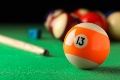 Photo of Billiard ball with number 13 on green table, closeup. Space for text