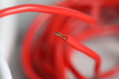 Red electrical wire on blurred background, closeup