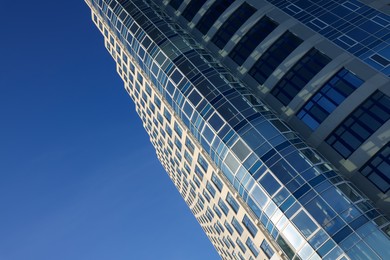 Beautiful skyscraper against blue sky on sunny day, low angle view