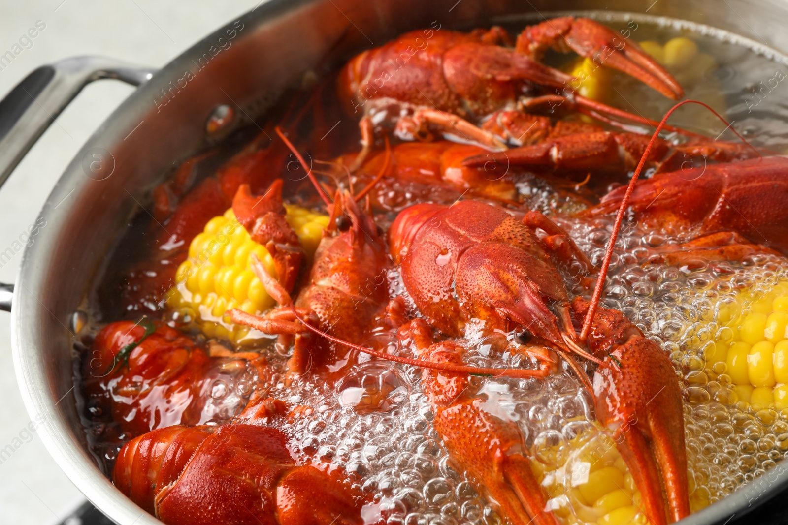 Photo of Fresh delicious crayfishes in boiling water, closeup