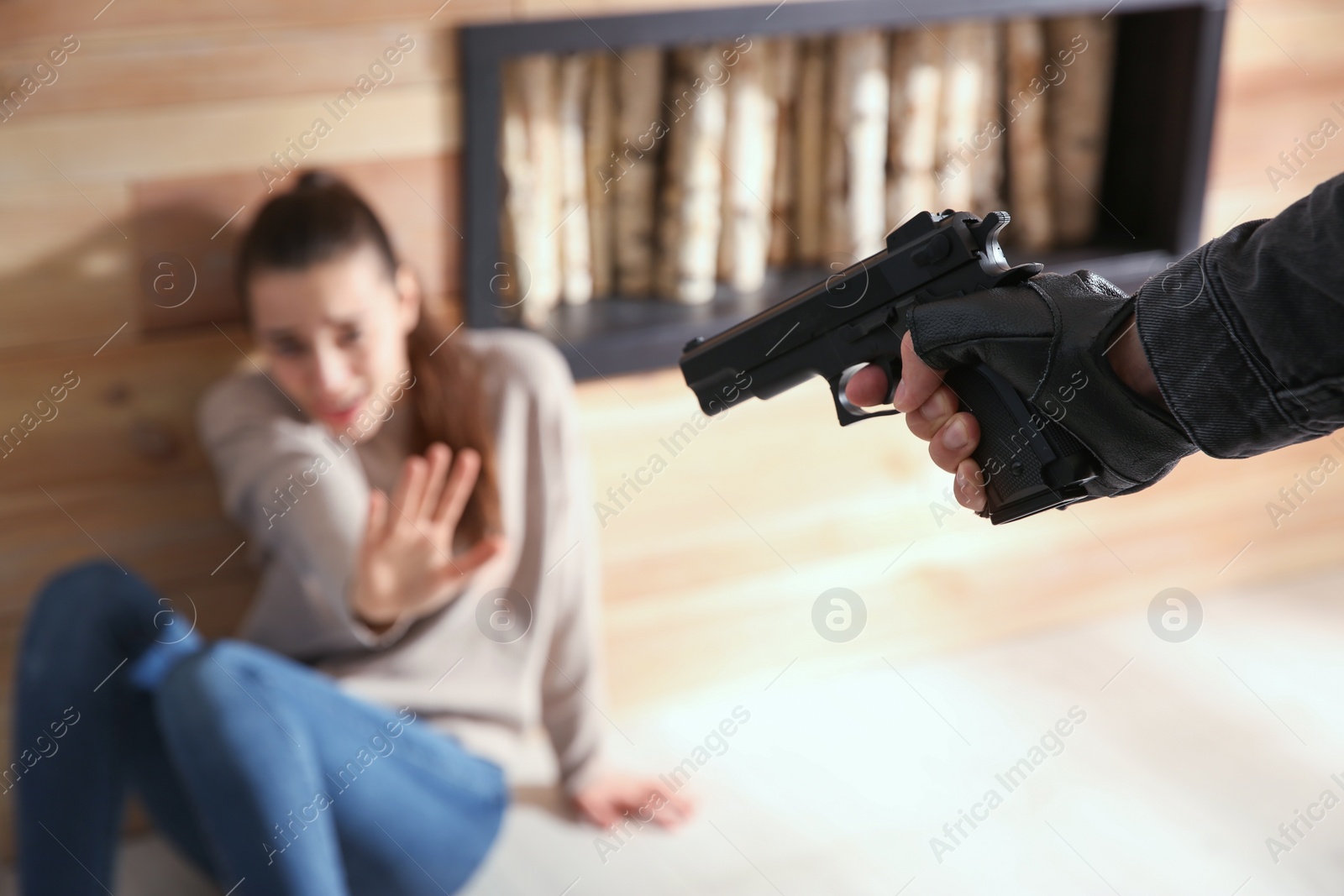 Photo of Man aiming his victim with gun indoors, closeup. Dangerous criminal