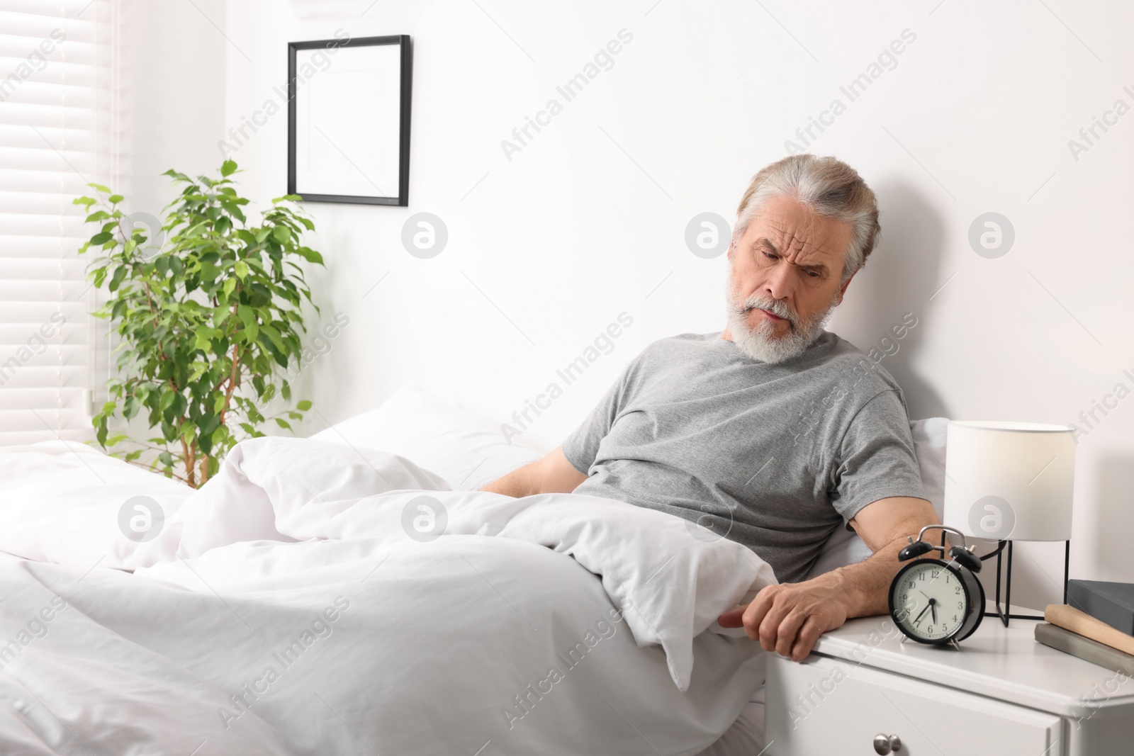 Photo of Sleepy senior man in bed at home