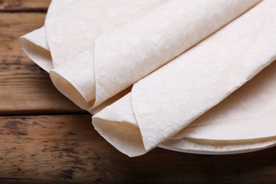 Delicious rolled Armenian lavash on wooden table, closeup