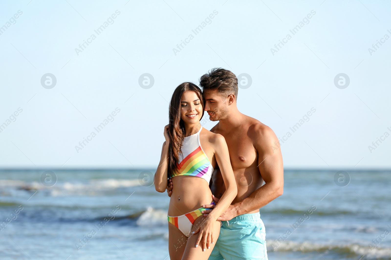 Photo of Happy young couple posing near sea on beach