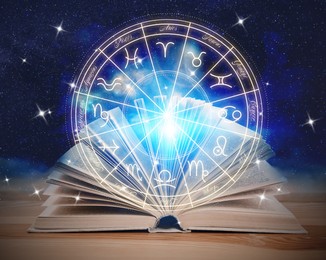 Image of Open book on wooden table, illustration of zodiac wheel with astrological signs and starry sky at night