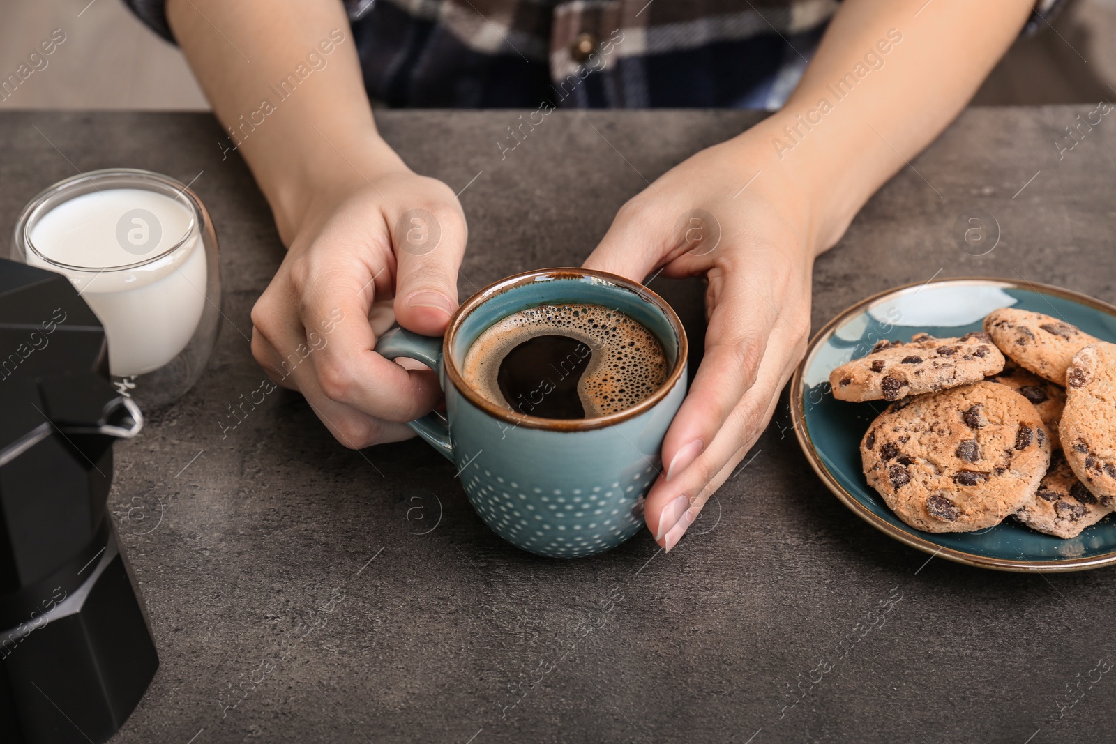 Photo of Woman with cup of aromatic hot coffee at table