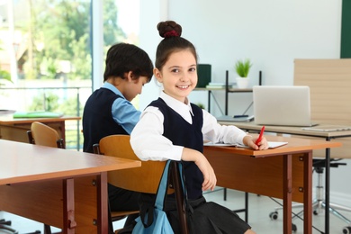 Girl wearing new school uniform in classroom