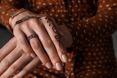 Photo of Woman with henna tattoo on hand, closeup and space for text. Traditional mehndi ornament