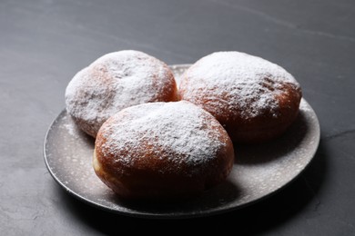 Photo of Delicious sweet buns on dark gray table, closeup