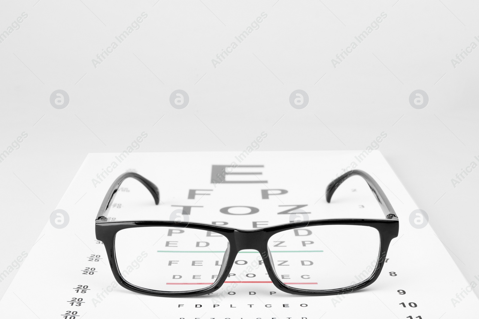 Photo of Glasses and vision test chart isolated on white