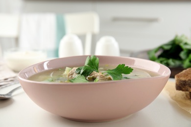 Photo of Delicious sorrel soup with meat and parsley served on white table