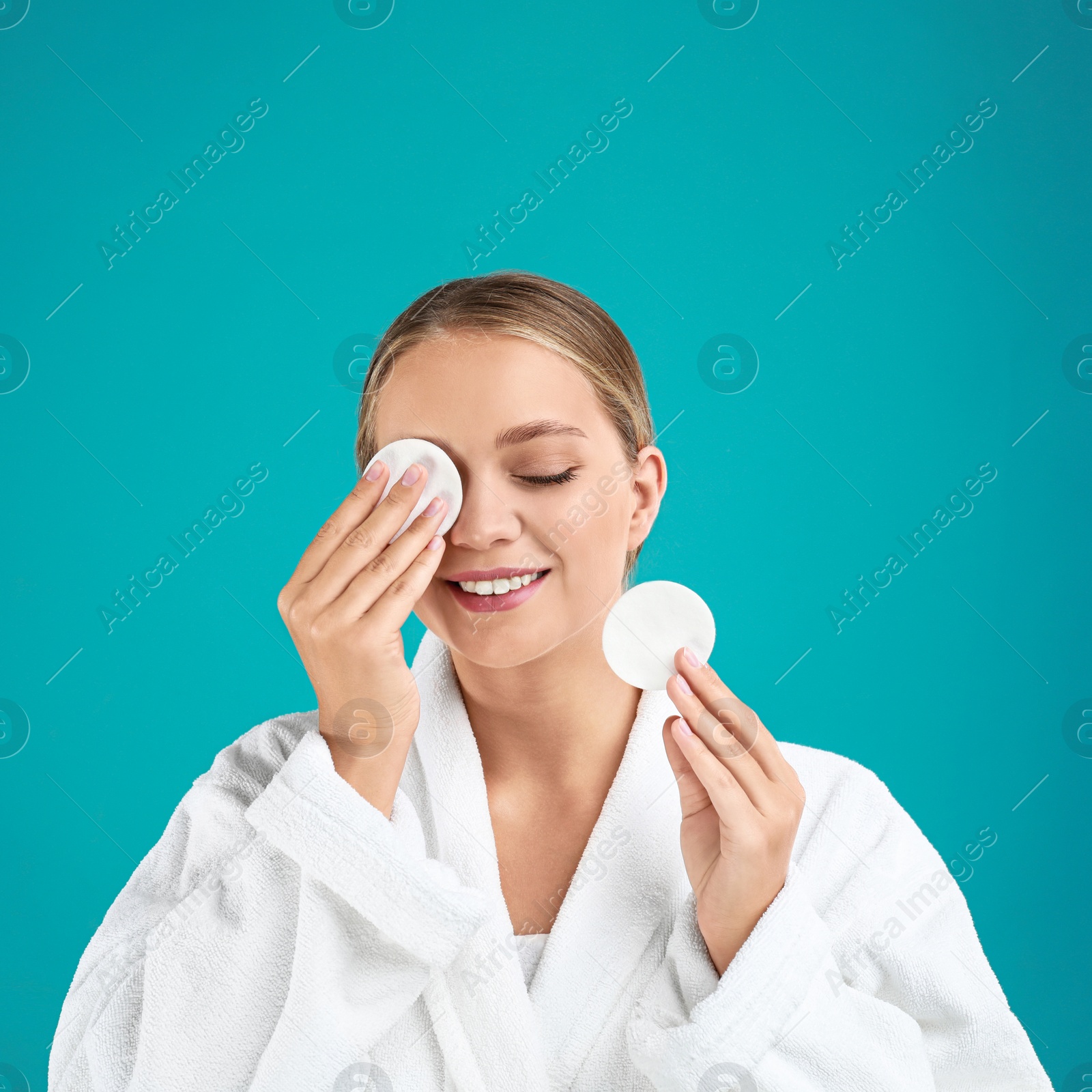 Photo of Beautiful young woman with cotton pads on turquoise background