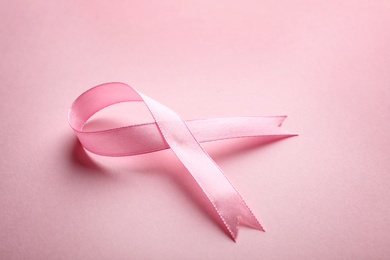 Pink ribbon on color background, space for text. Breast cancer awareness concept