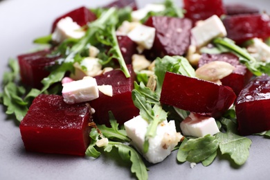 Photo of Delicious beet salad with arugula and feta cheese on plate, closeup