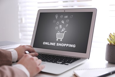 Woman using laptop for online shopping at table, closeup