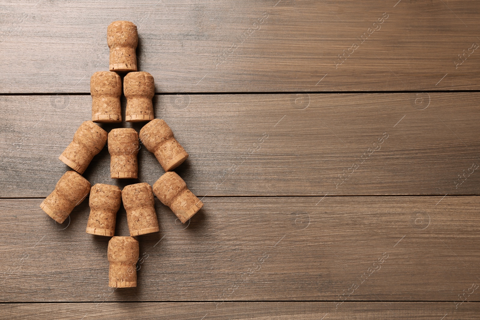 Photo of Christmas tree made of wine corks on wooden table, top view. Space for text