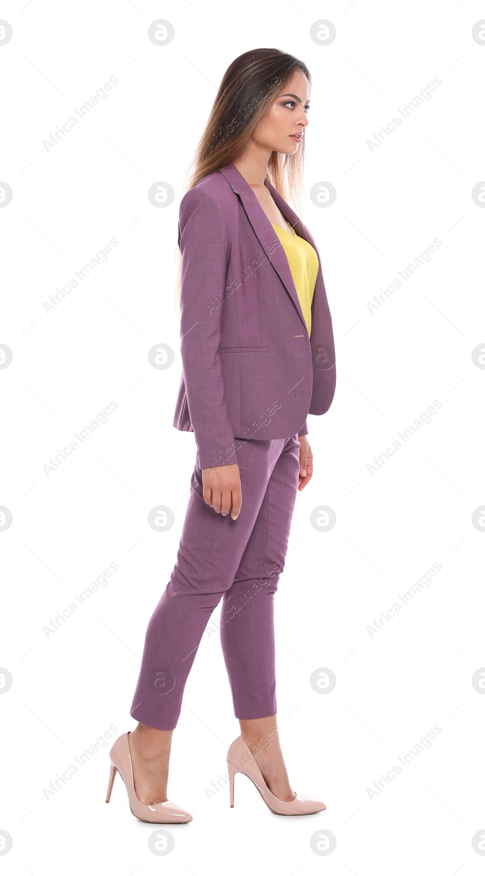 Photo of Beautiful young woman in business suit walking on white background