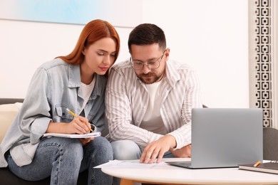 Photo of Couple doing taxes at table in living room