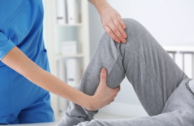 Doctor working with patient in hospital, closeup. Rehabilitation physiotherapy