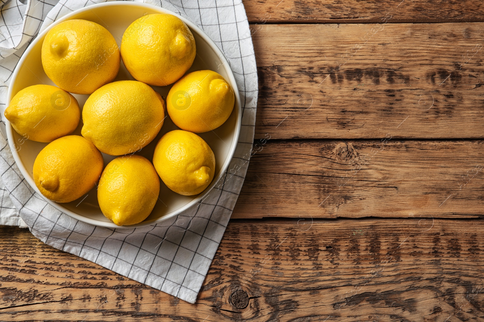 Photo of Plate with whole lemons on wooden background, top view