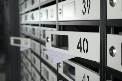 Photo of Open mailboxes with keyholes, numbers and receipts, closeup