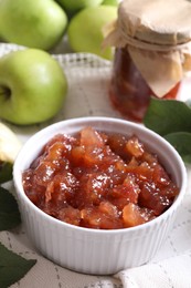 Photo of Bowl of delicious apple jam and fresh fruits on white tablecloth, closeup. Space for text