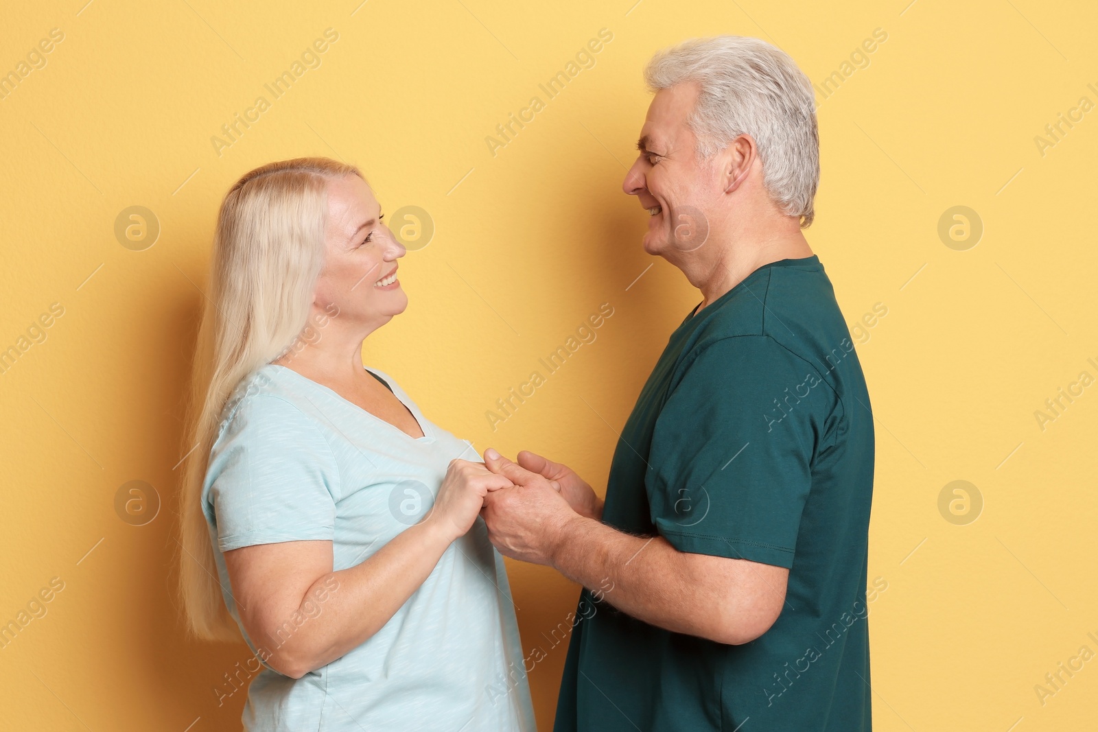 Photo of Portrait of adorable mature couple against color background