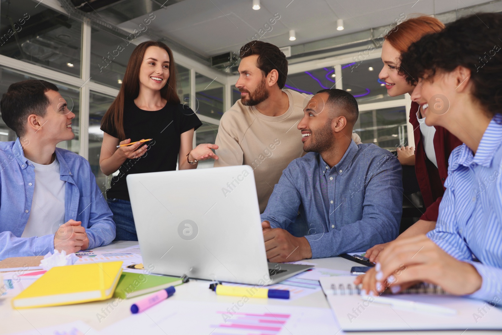 Photo of Team of employees working together at table in office. Startup project