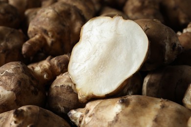 Whole and cut Jerusalem artichokes as background, closeup