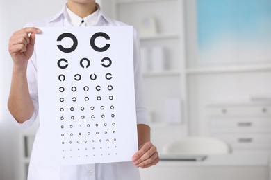 Photo of Ophthalmologist with vision test chart in clinic, closeup. Space for text