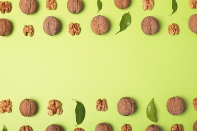 Group of walnuts on color background, flat lay with space for text