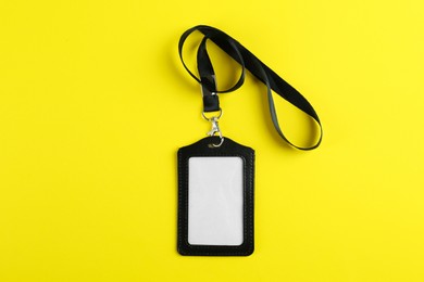 Photo of Blank badge on yellow background, top view. Mockup for design